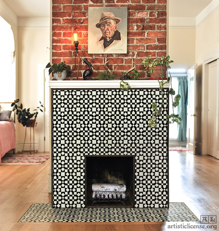 A contemporary fireplace mosaic artwork that is paired with hanging plants and minimal rustic design